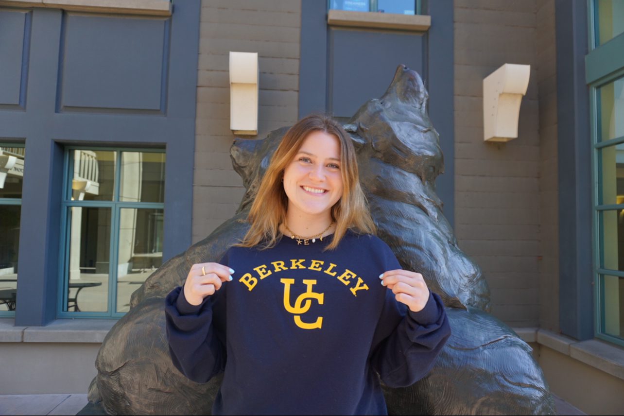 MBA student Emily Kargl stands in front of a sculpture of two bears wearing a UC Berkeley sweatshirt