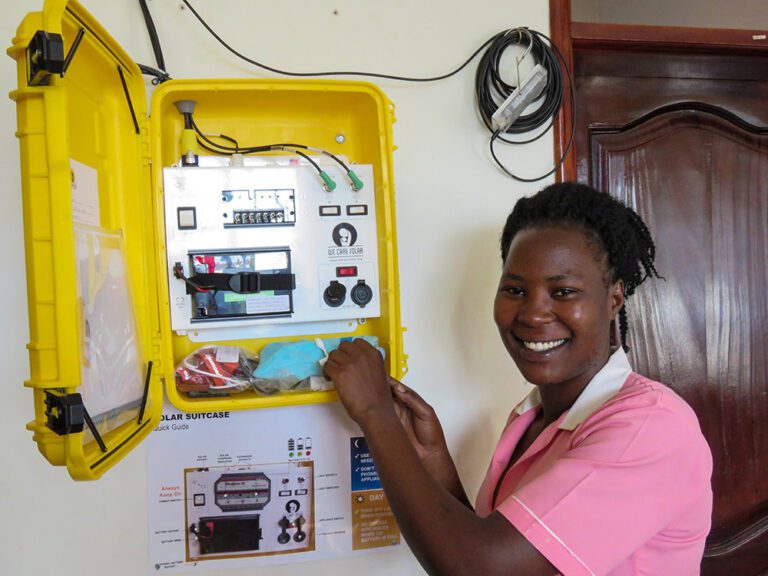 A woman standing in front of electrical box controlling solar energy panels