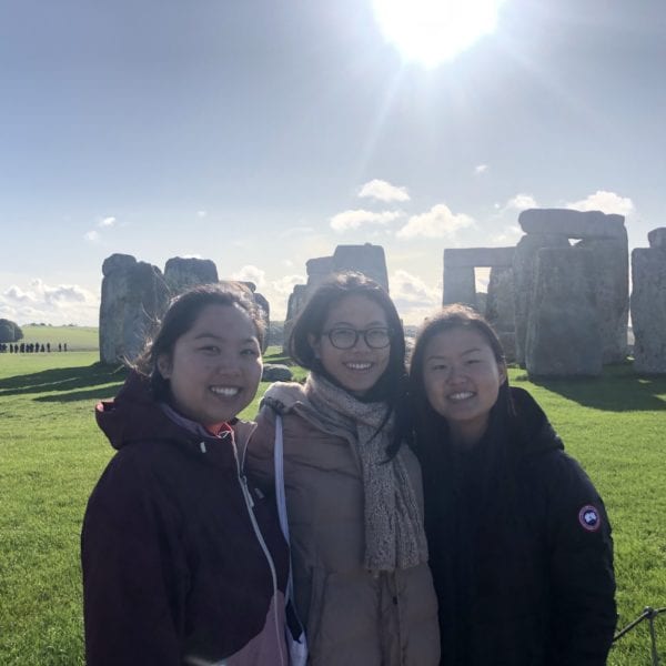 3 GMP students standing in front of stonehenge