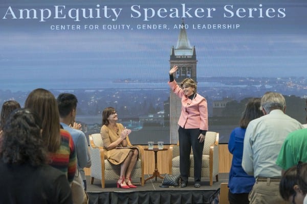 Gloria Allred stands on stage and waves to an audience