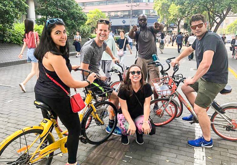 Five people smiling with bikes