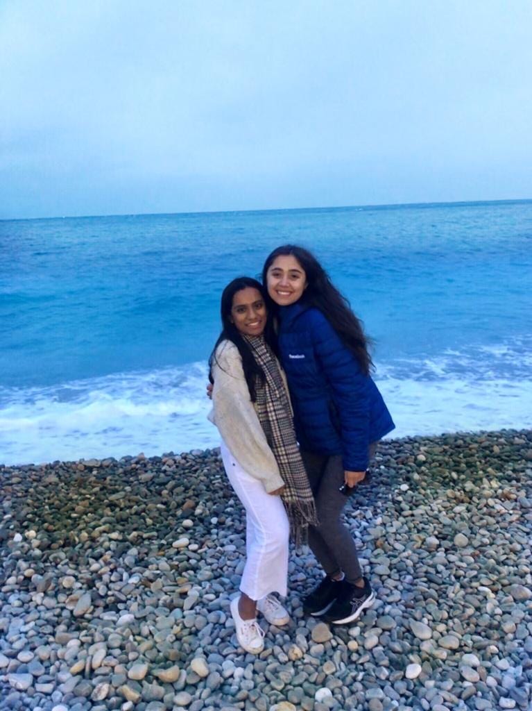 2 GMP students standing in front of the ocean.