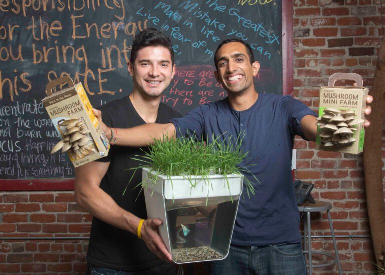 Co-founders of Back to the Roots holding products from their company and smiling at the camera