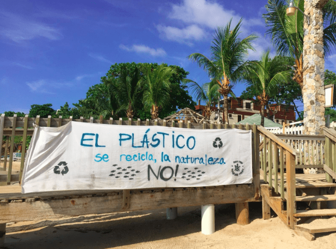 banner saying "El Plastico recicla, la naturaliza, no!"