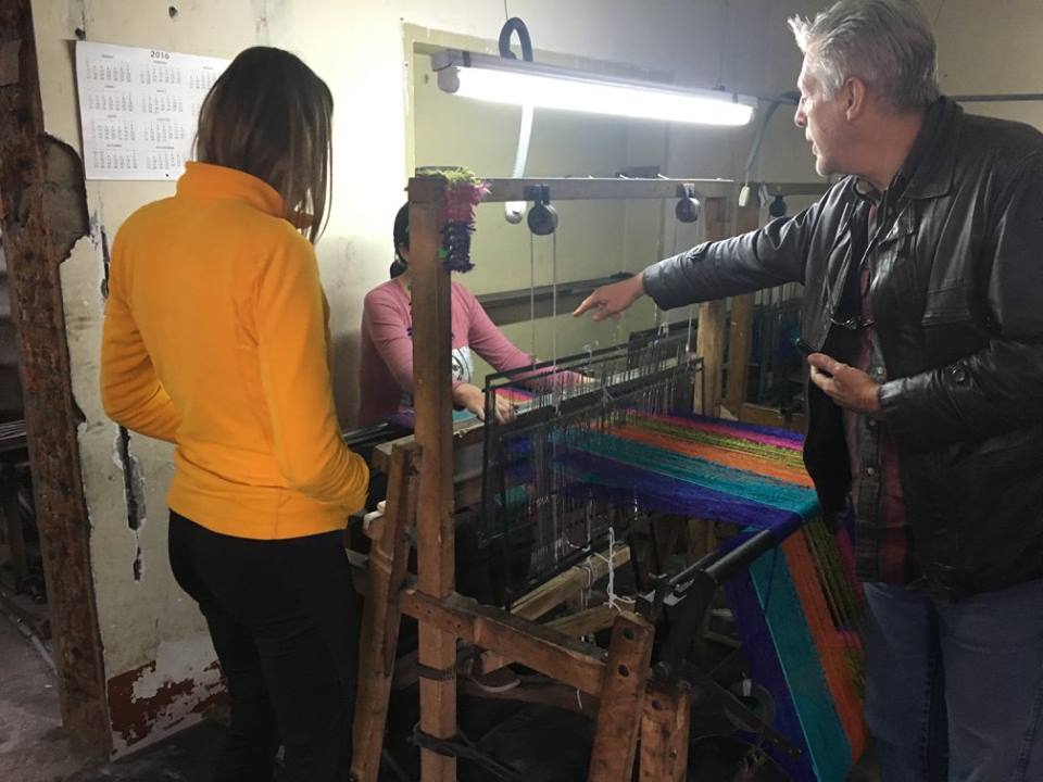 People talking to each other around a loom