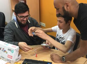 Amol mastering a self-driving car with Syrian students at a science workshop in Gaziantep.
